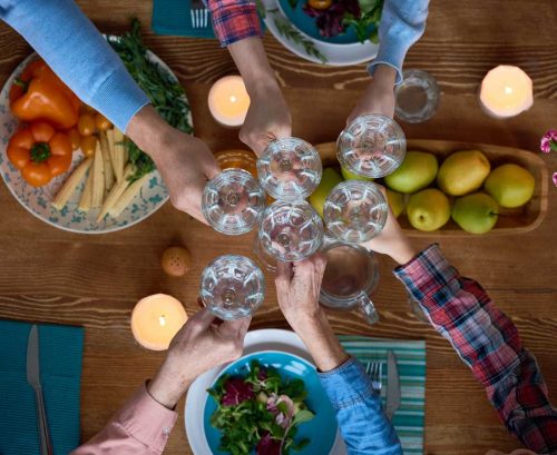 People toasting glasses of water at a table