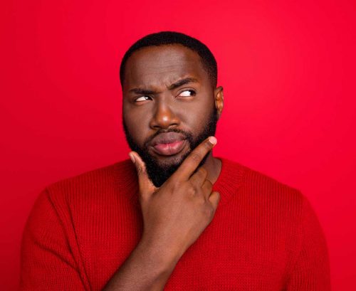 man in a red top wondering about something