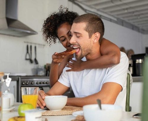 woman feeding wholegrain toast to her boyfriend