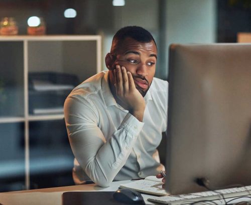 Man at computer looking tired