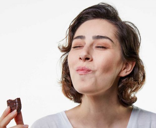 Woman eating a chocolate biscuit