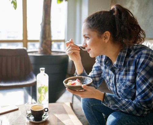 Woamn eating muesli in a cafe